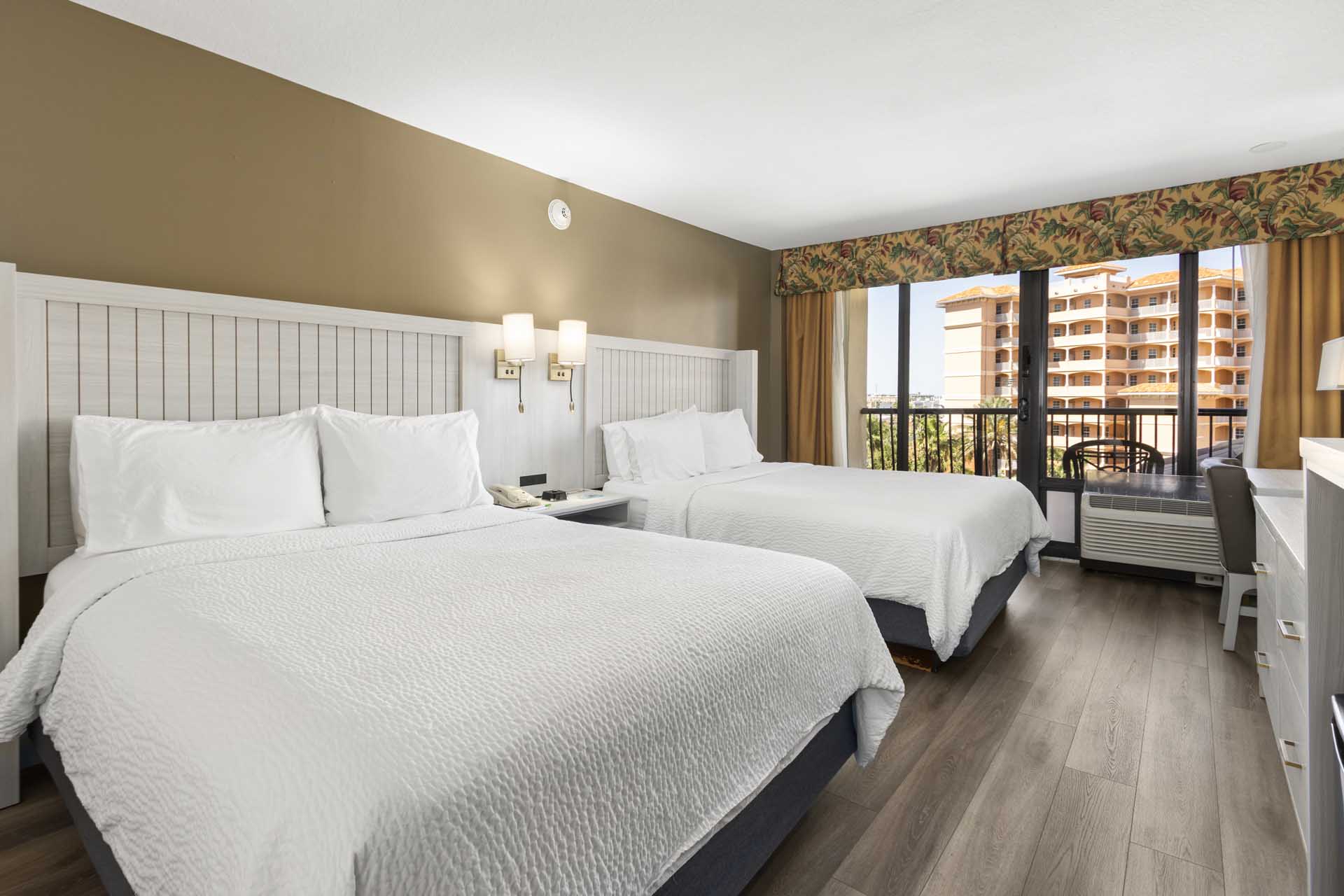 Two queen beds beside a private balcony